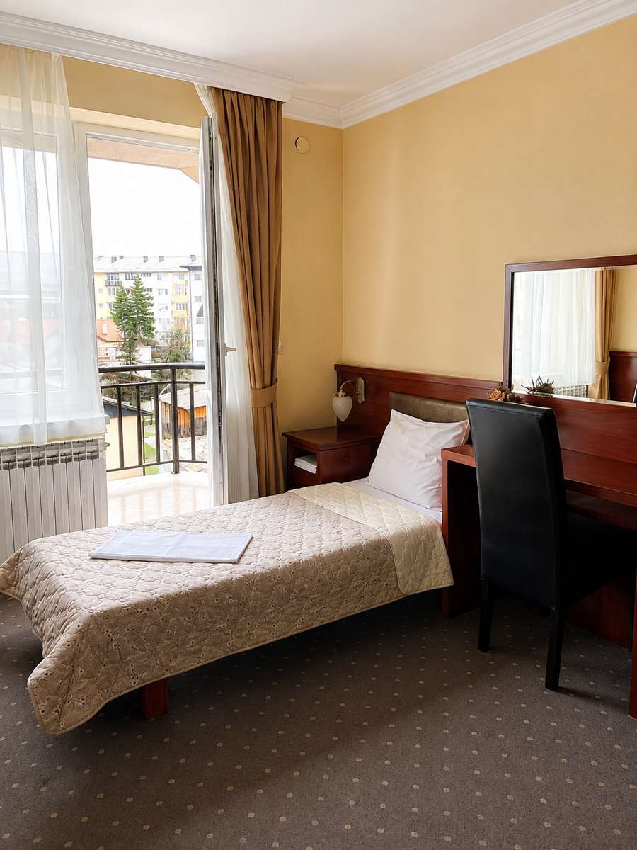 Jednokrevetna soba u Hotelu Kamel s jednim krevetom za jednu osobu, radnim stolom i velikim prozorom