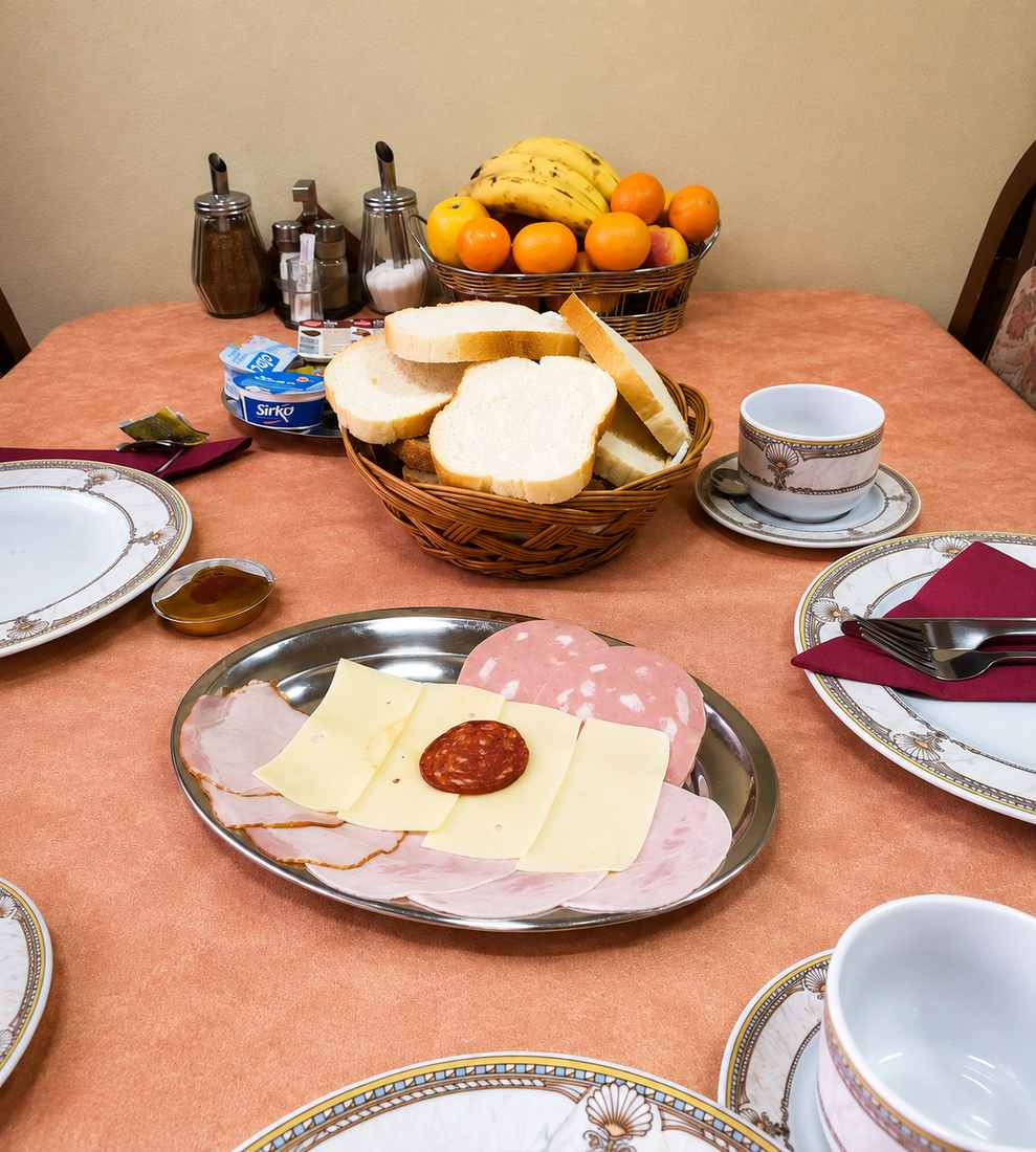 Sto za doručak u Hotelu Kamel s kruhom, narescima, sirom, svježim voćem i kafom
